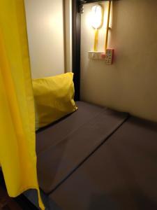 莱卡邦Best Bed Suvarnabhumi Hostel的一间设有黄色沙发和浅色装饰的客房