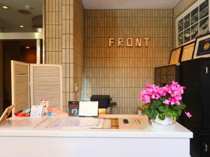 府中市府中俊宏商务酒店的商店的前台,有一团粉红色的花