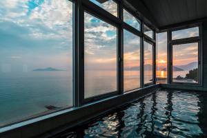 EtajimaUminos Spa & Resort的一座俯瞰大海的别墅内的游泳池