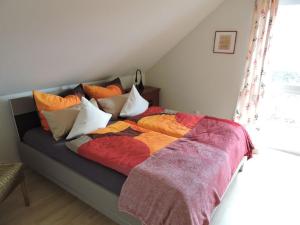 温特贝格Ferienhaus - Haus Winterberg的床上配有色彩缤纷的毯子和枕头