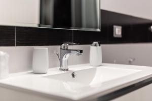 卡利亚里Nùe Rooms的浴室水槽设有水龙头和镜子