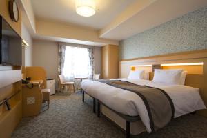 神户Hotel Monterey Kobe的酒店客房设有一张大床和一台电视。