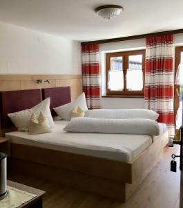 因泽尔Gästehaus Inzeller Hof的一间卧室设有两张床和窗户。