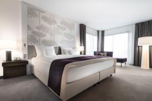 埃森大西洋埃森大酒店的卧室设有一张白色大床和大窗户