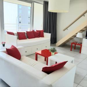 Wemmel19 Brussels Expo的客厅配有2张白色沙发和红色枕头