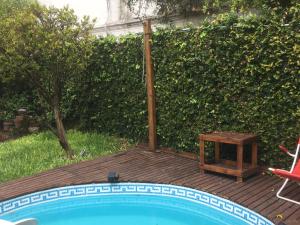 布宜诺斯艾利斯B&B Polo的一个带桌子和椅子的游泳池,位于树 ⁇ 旁