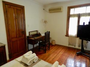 布宜诺斯艾利斯B&B Polo的客房配有书桌和带毛巾的床。