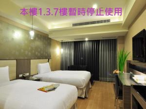 泰山君祥酒店 的酒店客房设有两张床和电视。