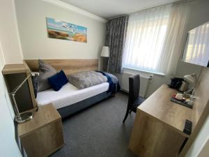 黑尔戈兰岛斯图本摩卡酒店的配有一张床和一张书桌的酒店客房