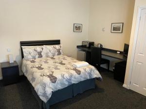 戴斯Ivy Cottage-Serviced accommodation的一间卧室配有一张床和一张带电脑的书桌