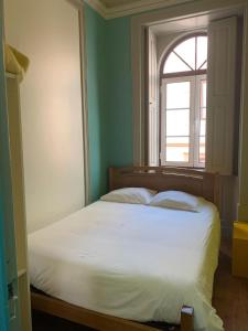 菲盖拉-达福什Meeting Hostel的卧室配有白色的床和窗户。