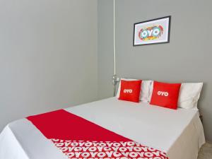 圣保罗OYO Hotel Castro Alves, São Paulo的一间卧室配有一张带两个红色枕头的床