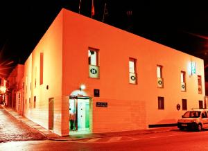圣费尔南多圣马科斯旅馆的一座橙色的建筑,前面有停车位
