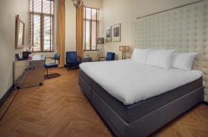 鹿特丹韦斯特考得酒店的卧室配有一张白色大床和一张书桌