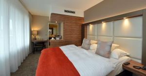 曼海姆贝斯特韦斯特黛尔塔公园酒店的一间卧室配有一张大床和一张书桌