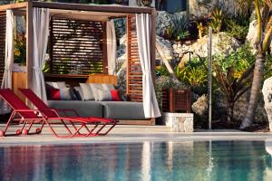 西湾Kimpton Seafire Resort + Spa, an IHG Hotel的游泳池旁的红色椅子和沙发