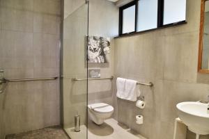 马翁Cresta Maun Hotel的带淋浴、卫生间和盥洗盆的浴室
