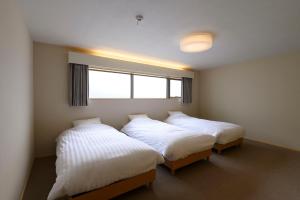 高山BEYOND HOTEL Takayama 4th的带窗户的客房内的两张床