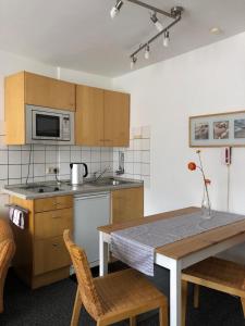 波鸿索邦公寓的厨房配有木制橱柜和桌椅