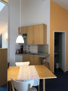 波鸿索邦公寓的厨房配有带椅子的木桌和桌子。
