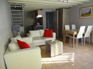 鲁汶鲁汶康多花园酒店的客厅配有白色沙发和红色枕头。