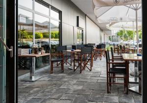 卢布尔雅那Urban Ring Hotel的餐厅设有木桌、椅子和窗户。