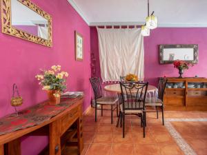 蒂约那马勒巴贾玛尔之家度假屋的用餐室设有粉红色的墙壁和桌椅