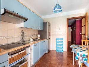 蒂约那马勒巴贾玛尔之家度假屋的厨房配有蓝色橱柜和桌子