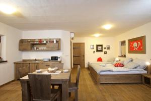 摩拉瓦托普利采帕诺斯卡沃什公寓式酒店的一间卧室配有一张床铺和一张桌子,还设有一间厨房