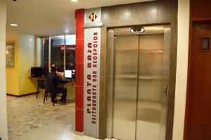 阿瓜斯卡连特斯伊丽莎白体育城酒店的电梯,在一座建筑物里,有一个人坐在桌子上