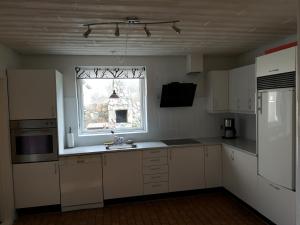 韦斯特维Logi i hus med kunst og have的厨房配有白色橱柜、窗户和水槽