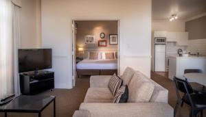 阿德莱德雄狮公寓酒店的客厅配有沙发和1张床