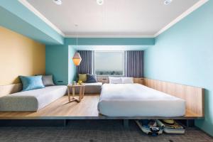 旭川OMO7 Asahikawa by Hoshino Resorts的一间卧室配有两张床和一张桌子