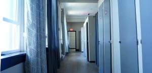 温哥华HI Vancouver Jericho Beach - Hostel的医院里带蓝色墙壁和窗户的走廊