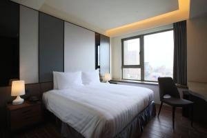 台南Hotel A 圣禾大饭店的一间设有大床和窗户的酒店客房