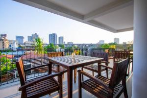 曼谷Lily Hotel Bangkok的阳台上的木桌和椅子