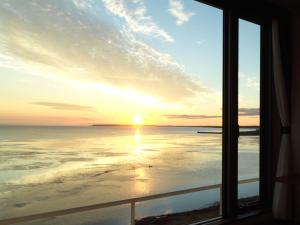 北见佐吕间湖鹤雅休闲度假温泉酒店的日落时分从一扇海景窗户欣赏美景