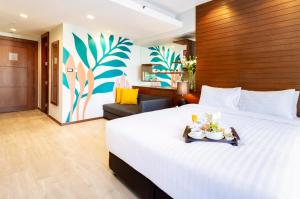 曼谷西隆富丽萨通酒店的酒店客房设有一张大床,上面放着一盘食物