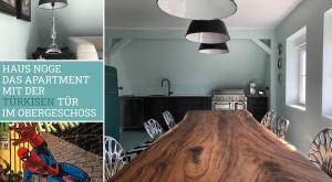 韦斯特兰Haus Noge Sylt - Offizierhaus Design Appartments strandnah的厨房里设有1间带木桌的用餐室