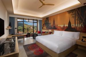 Menghai西双版纳悦椿温泉度假酒店的一间带白色大床的卧室和一间客厅