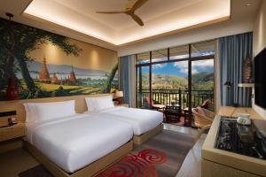 Menghai西双版纳悦椿温泉度假酒店的一间卧室设有两张床和大窗户