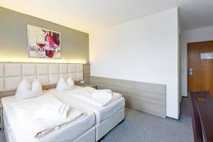 斯图加特巴伐利亚慕尼黑高级酒店的酒店客房配有一张带白色枕头的大床