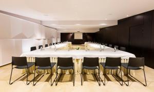 塞维利亚费尔南多III号酒店的一间会议室,配有一张白色的大桌子和椅子