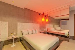 福塔莱萨阿萨依汽车旅馆（仅限成人）的一间卧室配有两张床和镜子