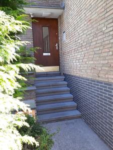 比勒费尔德Apartment Jackie 2的楼梯通往砖砌建筑,设有棕色的门