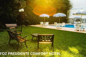 伊瓜苏福斯总统康福特茵酒店的院子里的一组桌椅和遮阳伞