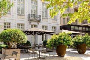 根特Pillows Grand Boutique Hotel Reylof Ghent的一座配有桌椅的户外庭院和一座建筑