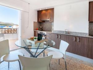 兰卡Apartment Blue Ocean-3 by Interhome的厨房配有玻璃桌和白色椅子