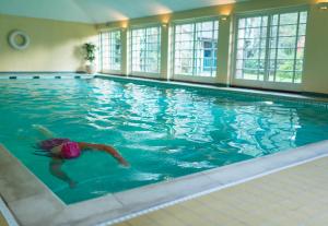 约克米德尔索普Spa酒店的在大型游泳池游泳的人