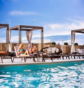 里诺德洛银色传统里诺赌场度假村酒店的一群人坐在游泳池旁的躺椅上